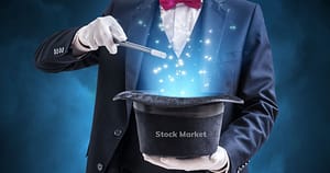 magician performing a trick using a hat with the word stock market on it.